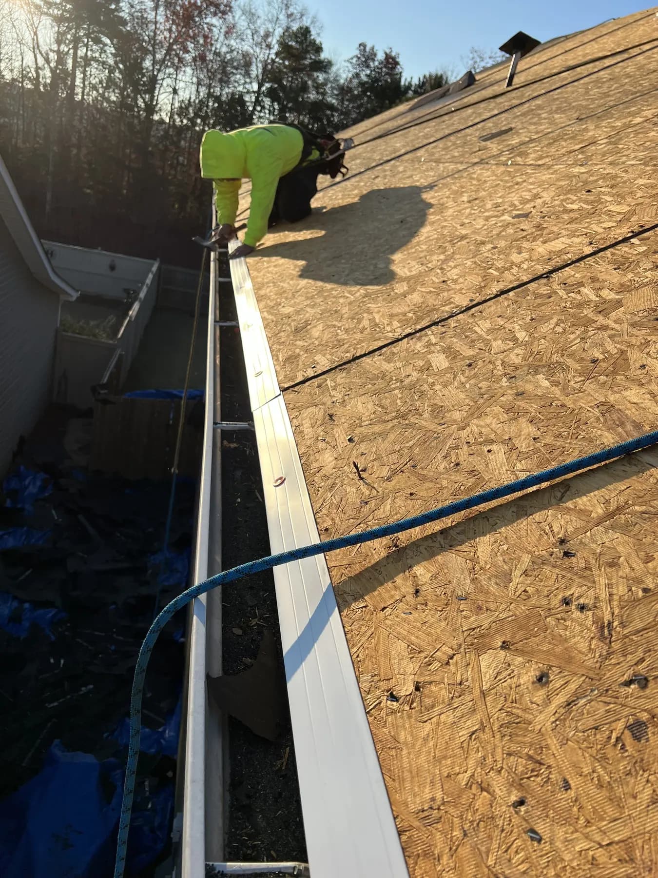 Worker installing metal edge detail along an exposed roof deck