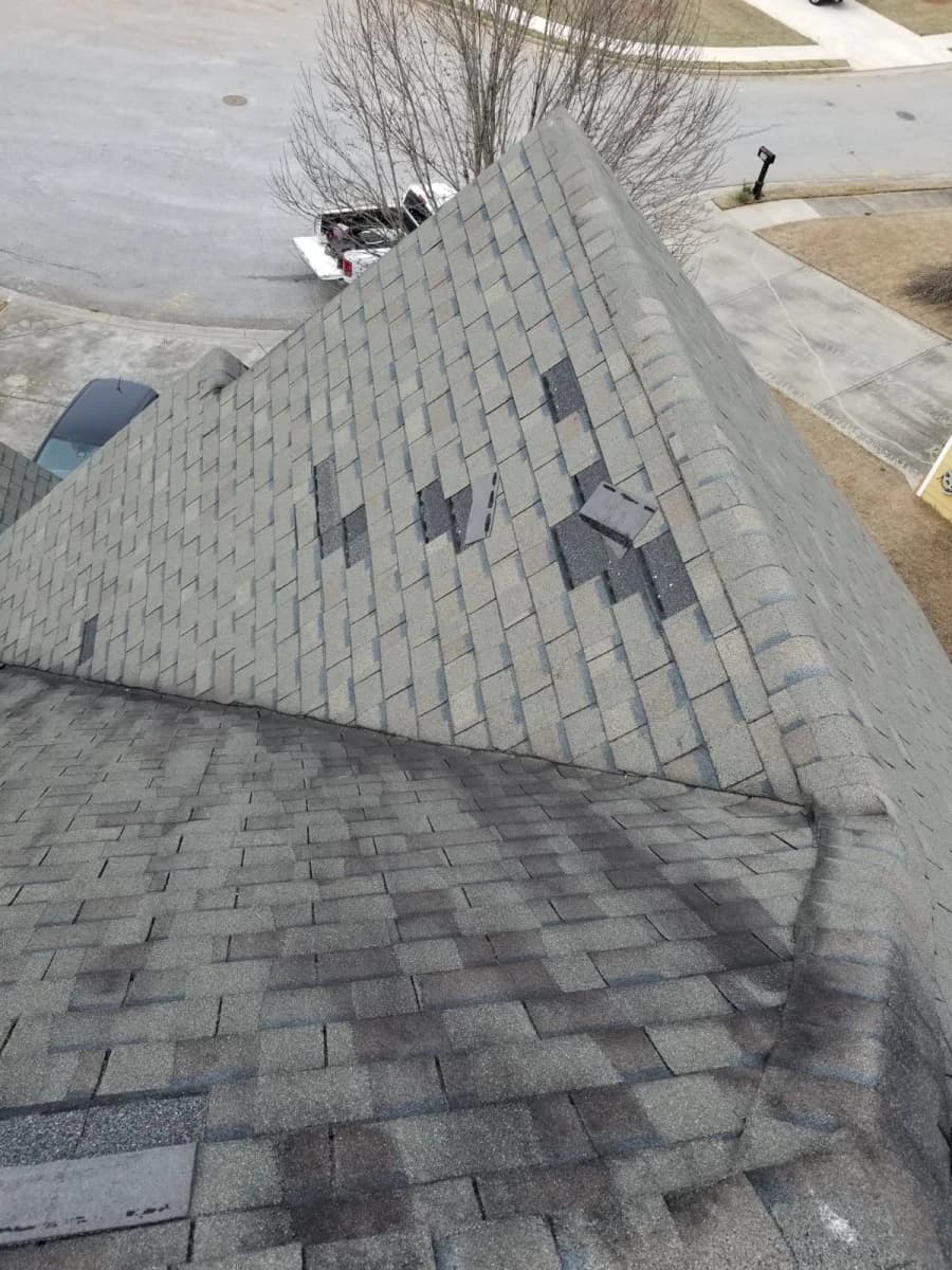 Damaged asphalt shingles visible on a roof plane