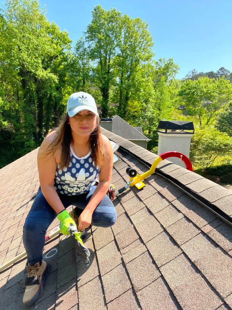 Worker seated beside tools on a roof