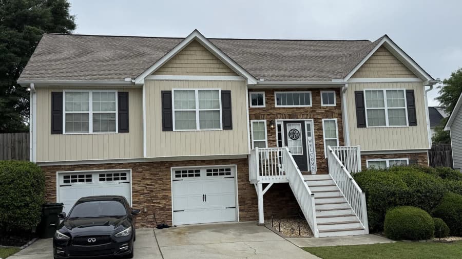 Completed residential front elevation with a dark shingle roof