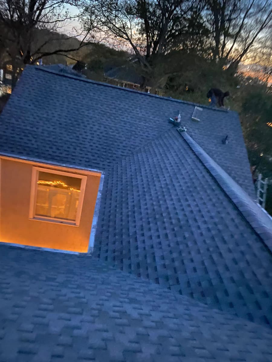 Completed dark architectural shingle roof on a home