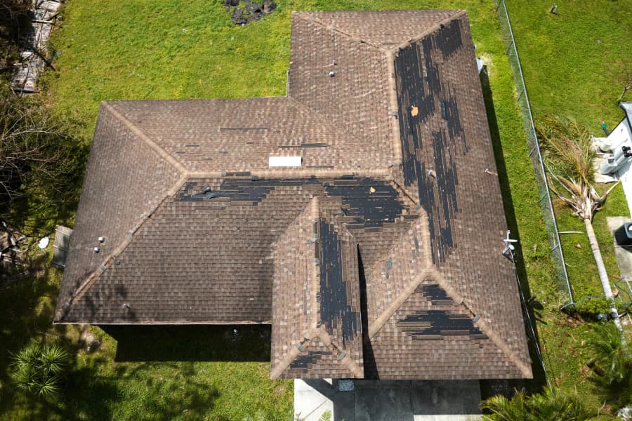 Residential roof viewed from above with exposed shingle sections